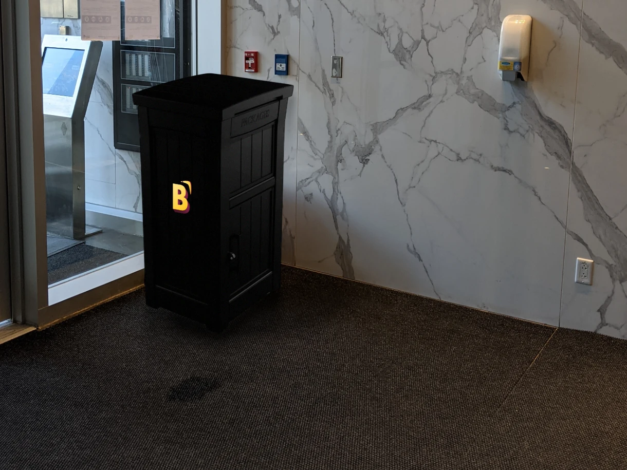 The BOOMRG parcel drop box standing in the lobby of the O'Nessy condominium, beside the entrance.